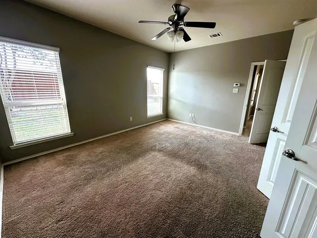 a view of a livingroom with a ceiling fan and window