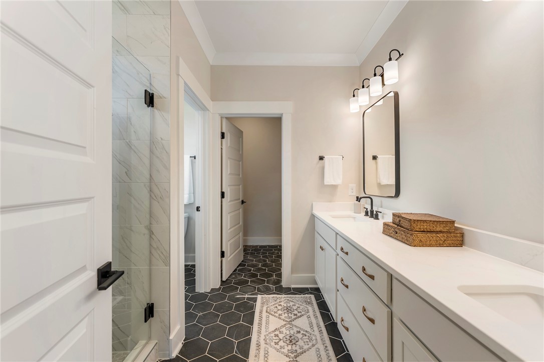 506 Tilman Court Anderson, SC 29621 - Photo 12 of 20 Modern bathroom featuring sleek vanity with ample storage and elegant hexagon tile flooring.
