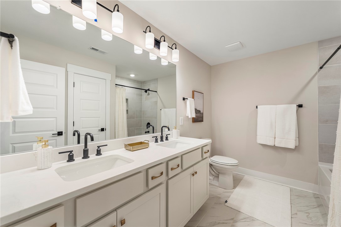 506 Tilman Court Anderson, SC 29621 - Photo 17 of 20 This sleek bathroom features a double vanity and a shower-tub combination, all with contemporary fixtures.