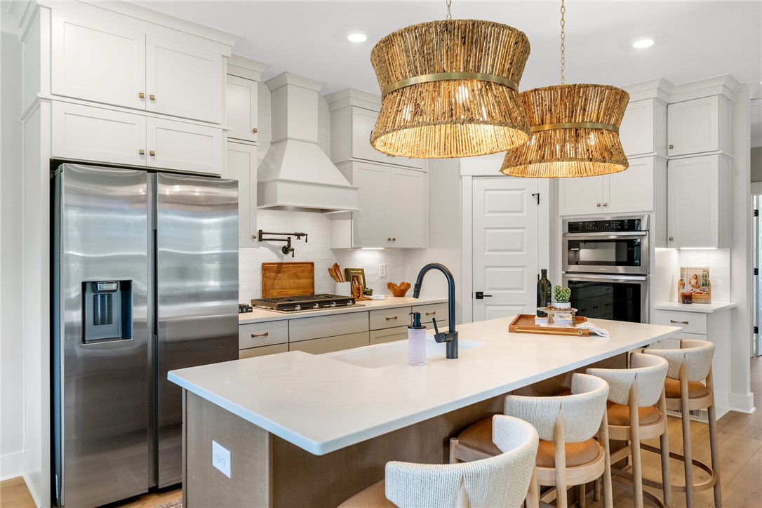 506 Tilman Court Anderson, SC 29621 - Photo 7 of 20 This modern kitchen features a spacious island, sleek appliances, and elegant lighting, ideal for culinary endeavors.