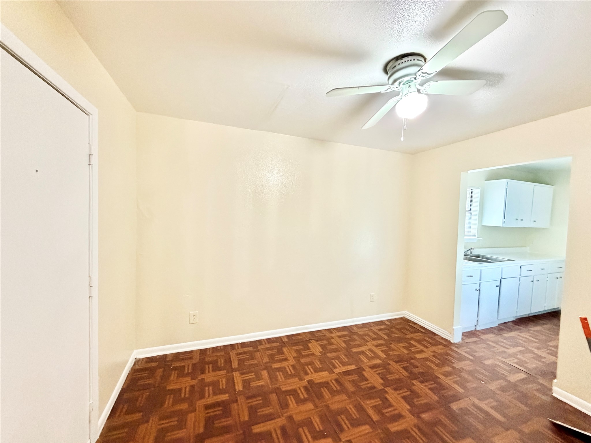 6257 Manor Road, Unit B Austin, TX 78723 - Photo 6 of 38 Room featuring patterned wood-finish flooring, light-toned walls, and a ceiling fan with integrated lighting