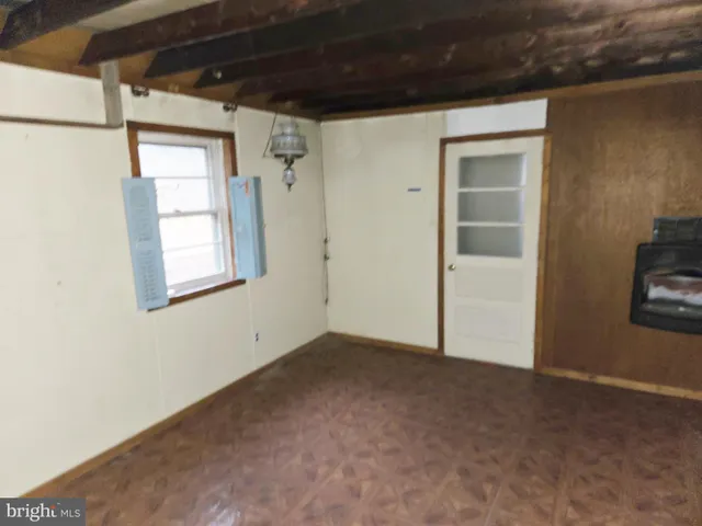 a view of a hallway with wooden floor and a bathroom