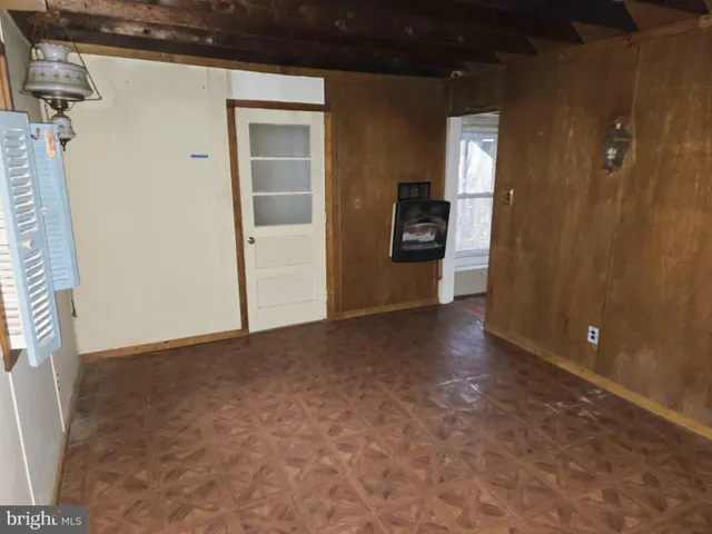 a view of an empty room with a fireplace and a window