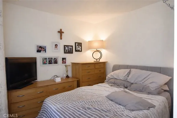 a bedroom with a bed and a flat screen tv