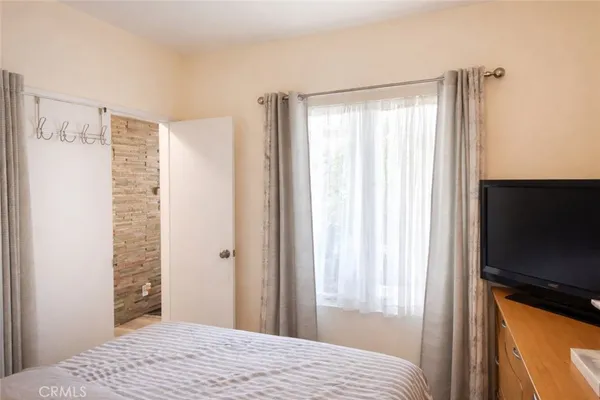 a bedroom with a bed and a television