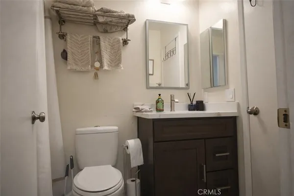 a bathroom with a sink vanity mirror and toilet