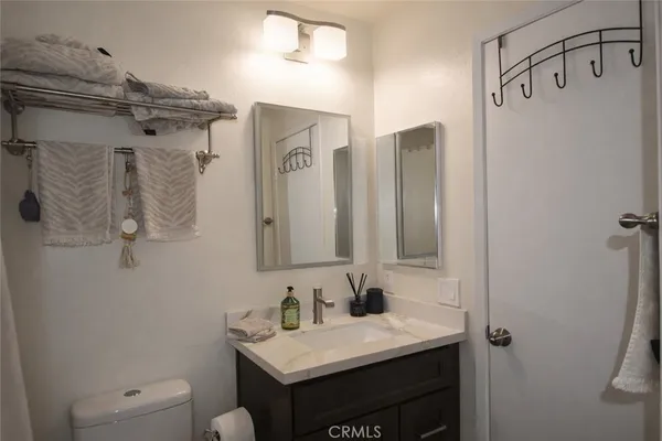 a bathroom with a sink vanity mirror and toilet