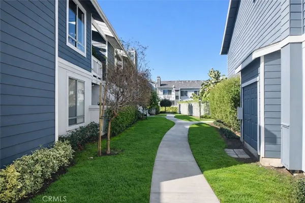 a view of a house with a yard and pathway