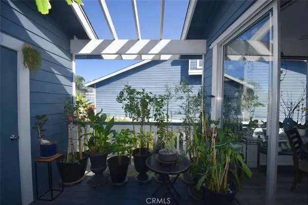 a view of a balcony with chairs potted plants