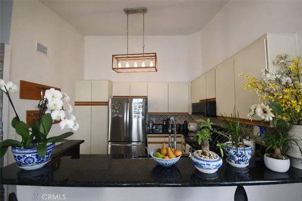 a view of a dining room with furniture a kitchen and a stove