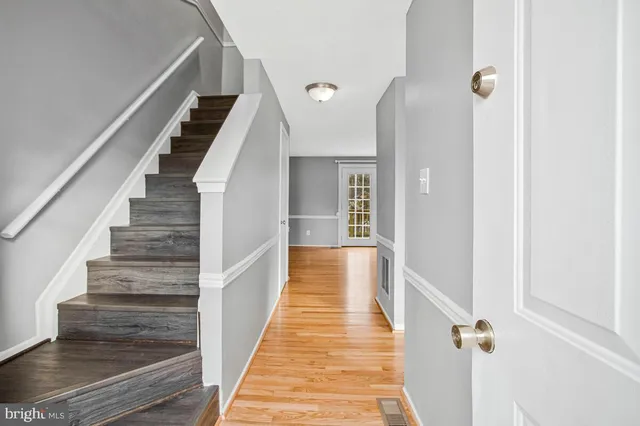 a view of a hallway with wooden floor and staircase