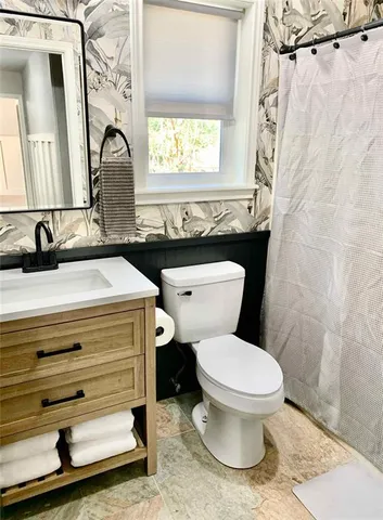 a bathroom with a sink a toilet and a mirror