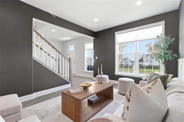 a living room with furniture a large window and a chandelier