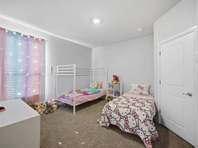 a bedroom with two beds and window