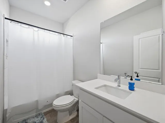 a bathroom with a granite countertop sink toilet and a mirror