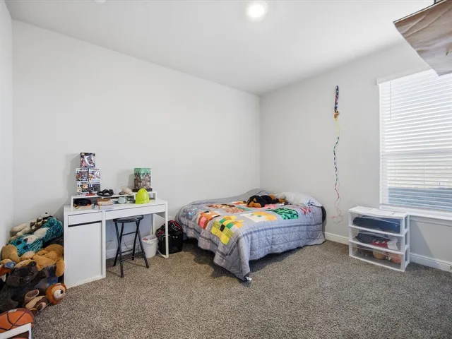 a bedroom with a bed and a desk in it