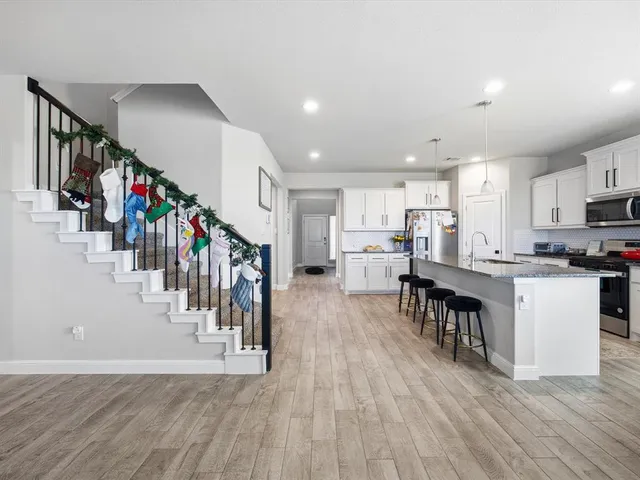 a living room with lots of wooden furniture and kitchen view