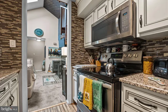 a kitchen with stainless steel appliances granite countertop a stove and a microwave