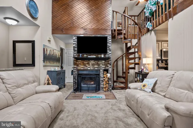 a living room with furniture a flat screen tv and a fireplace