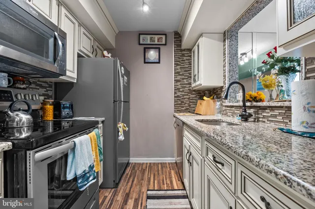 a kitchen with granite countertop a sink stove and cabinets
