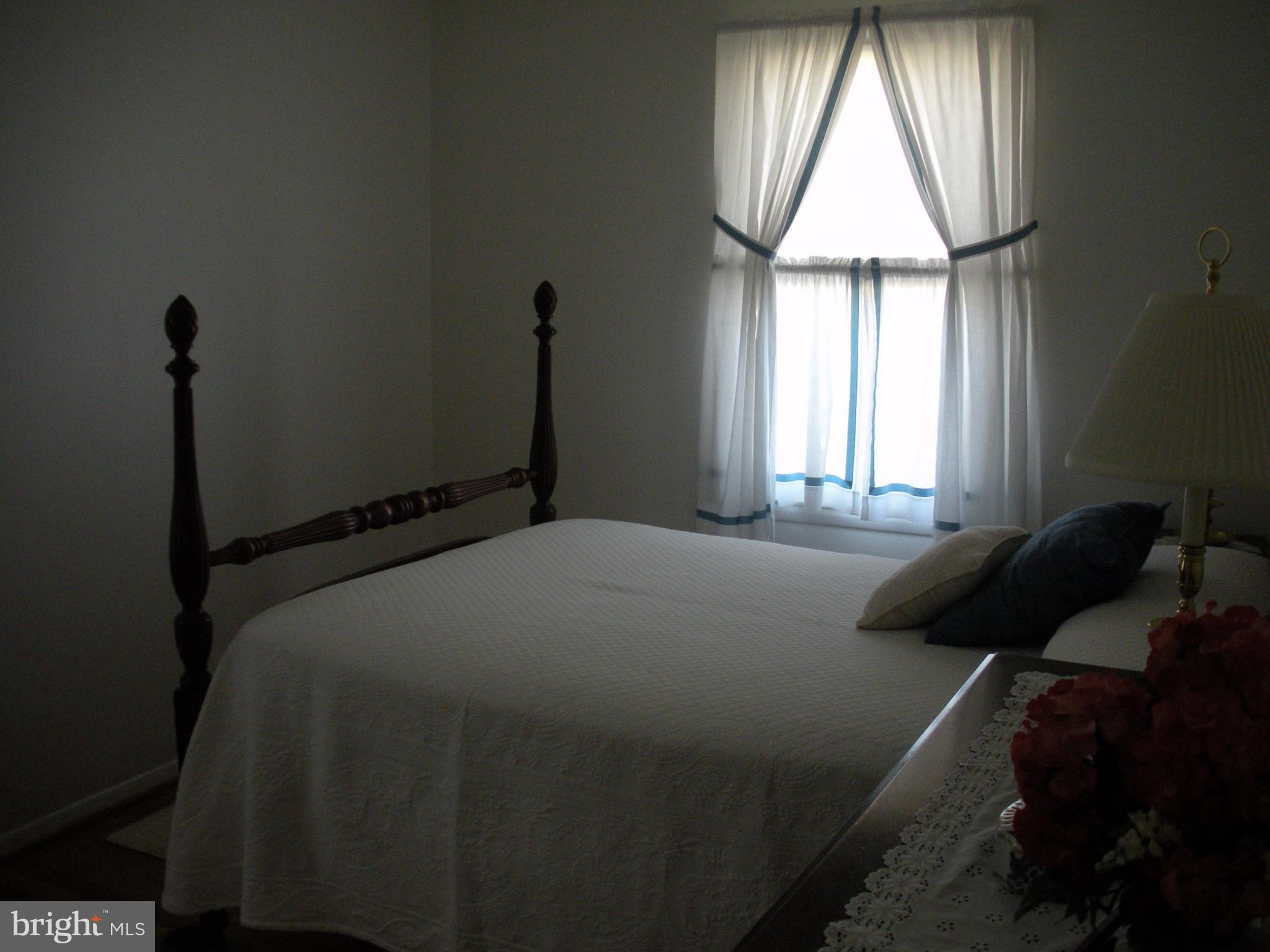 8803 Parlo Road Baltimore, MD 21236 - Photo 16 of 29 a bed sitting in a bedroom next to a window