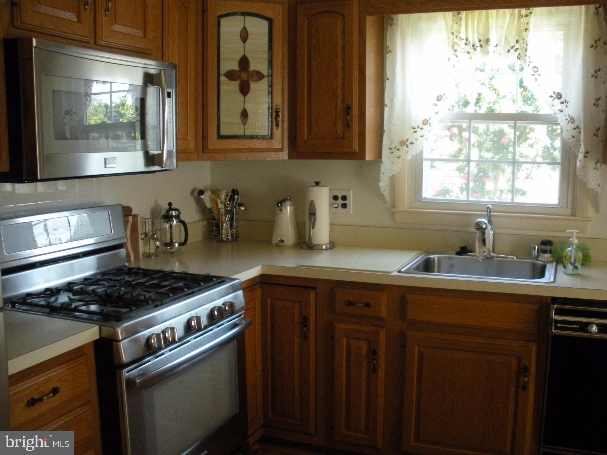 8803 Parlo Road Baltimore, MD 21236 - Photo 3 of 29 a kitchen with stainless steel appliances a sink stove and cabinets