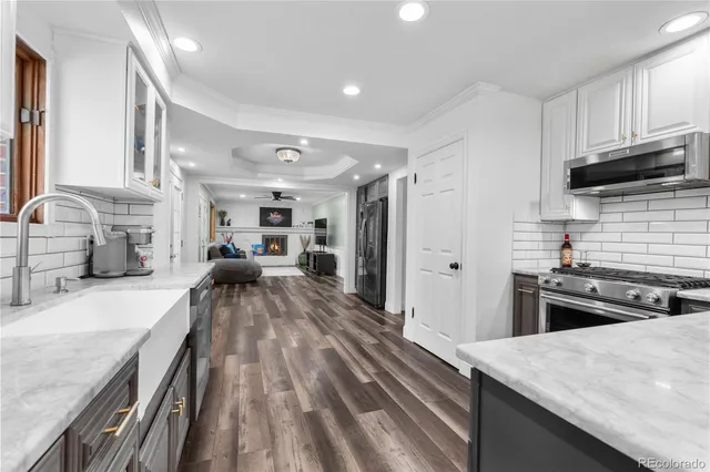 a large kitchen with kitchen island a stove a sink dishwasher and wooden cabinets with wooden floor