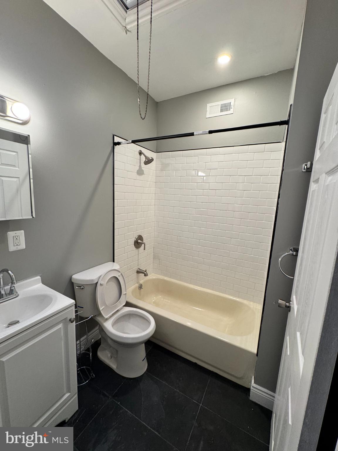 1908 West Somerset Street Philadelphia, PA 19132 - Photo 6 of 10 a bathroom with a sink a toilet a mirror a bathtub and shower