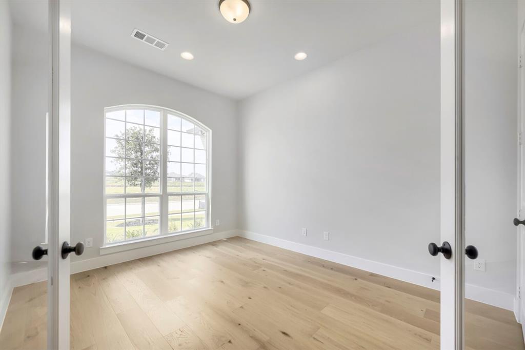799 Mandrake Road Haslet, TX 76052 - Photo 5 of 27 an empty room with wooden floor and windows