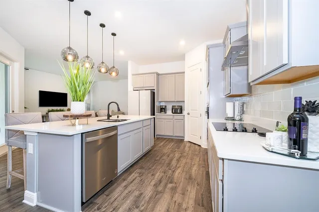 a kitchen with a sink a counter top space and living room view