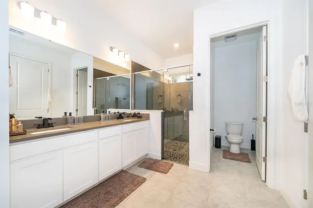 a bathroom with a double vanity sink toilet and shower