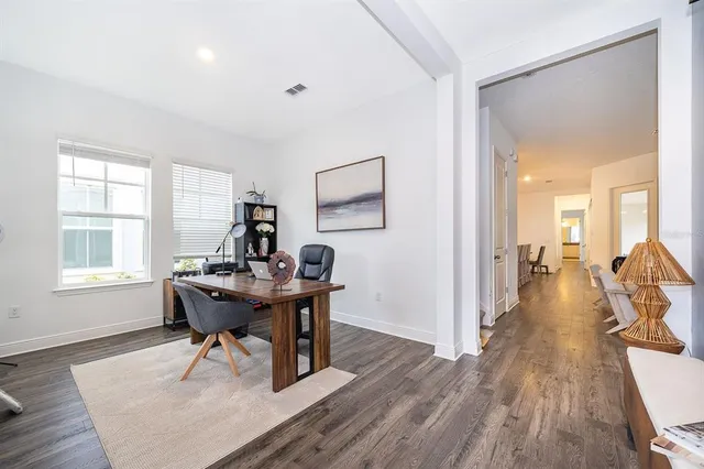 a view of a workspace with wooden floor and a window