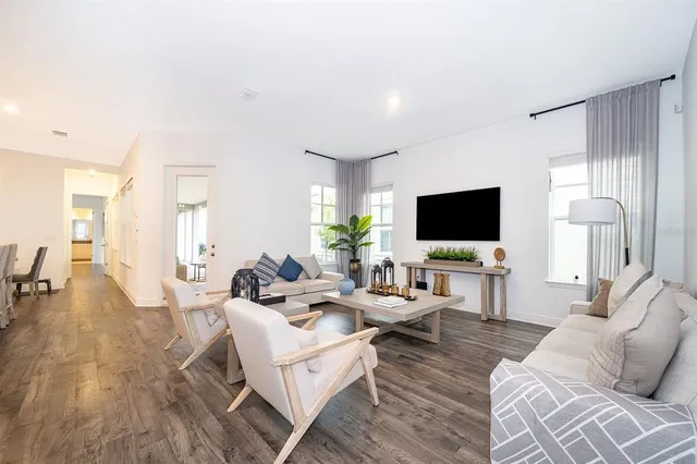 a living room with furniture wooden floor and a flat screen tv