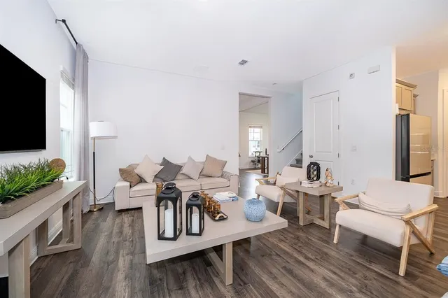 a living room with furniture wooden floor and a flat screen tv