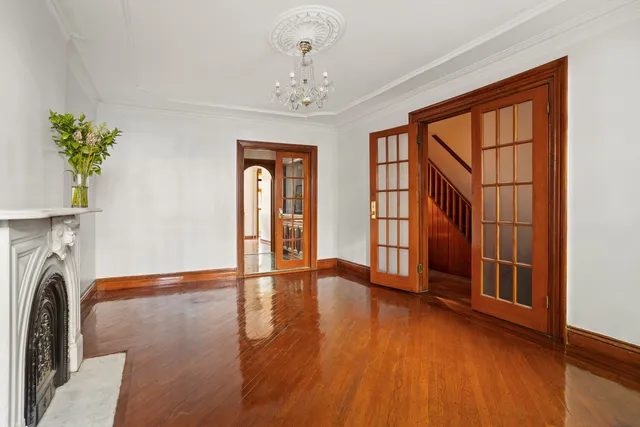 a view of an empty room with window and wooden floor