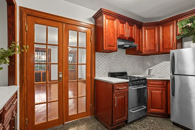 a kitchen with stainless steel appliances granite countertop a stove a refrigerator and a window