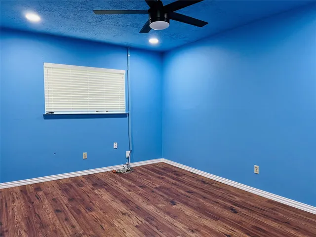 a view of a room with wooden floor and a window