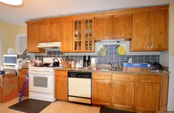 a kitchen with stainless steel appliances granite countertop wooden cabinets a stove a sink and dishwasher