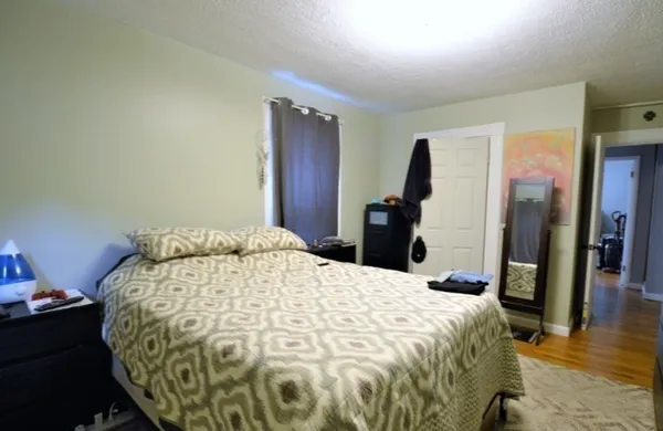 a bed sitting in a bedroom and a mirror