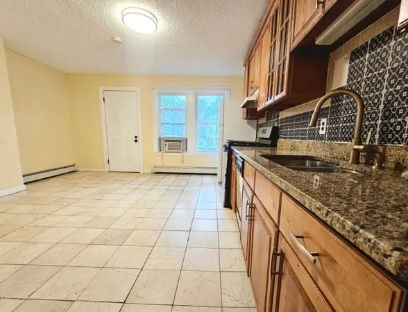 a kitchen with granite countertop a sink and a stove