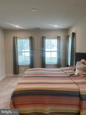 a bedroom with a bed and a large window