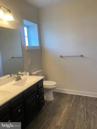 a bathroom with a granite countertop sink toilet and a mirror