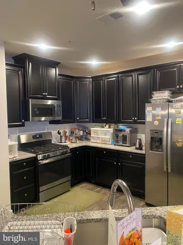 a kitchen with granite countertop stainless steel appliances and wooden cabinets