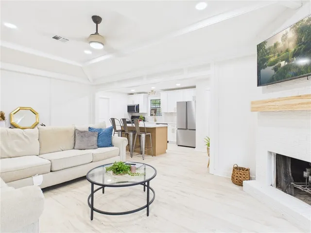 a living room with furniture a fireplace and a flat screen tv