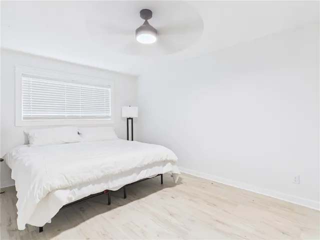 a bedroom with a bed and a ceiling fan