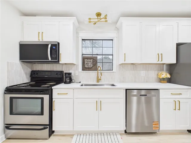 a kitchen with stainless steel appliances a refrigerator and a stove top oven