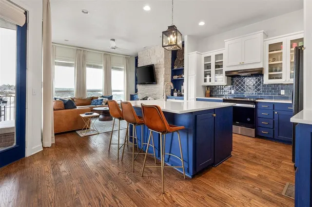 a large kitchen with lots of counter space a sink and chairs