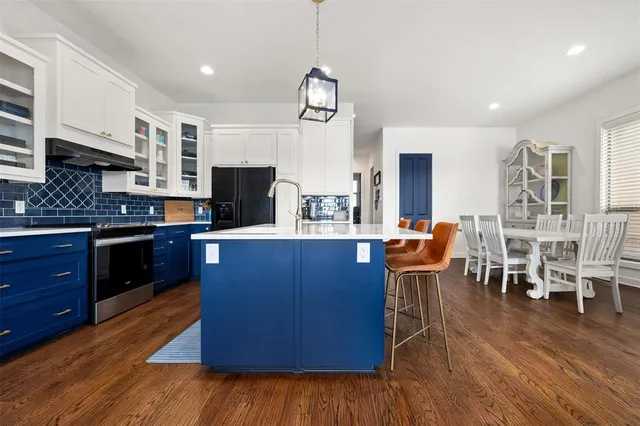 a kitchen with stainless steel appliances granite countertop wooden floors and wooden cabinets