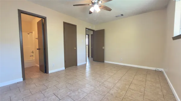 an empty room with fan and entrance