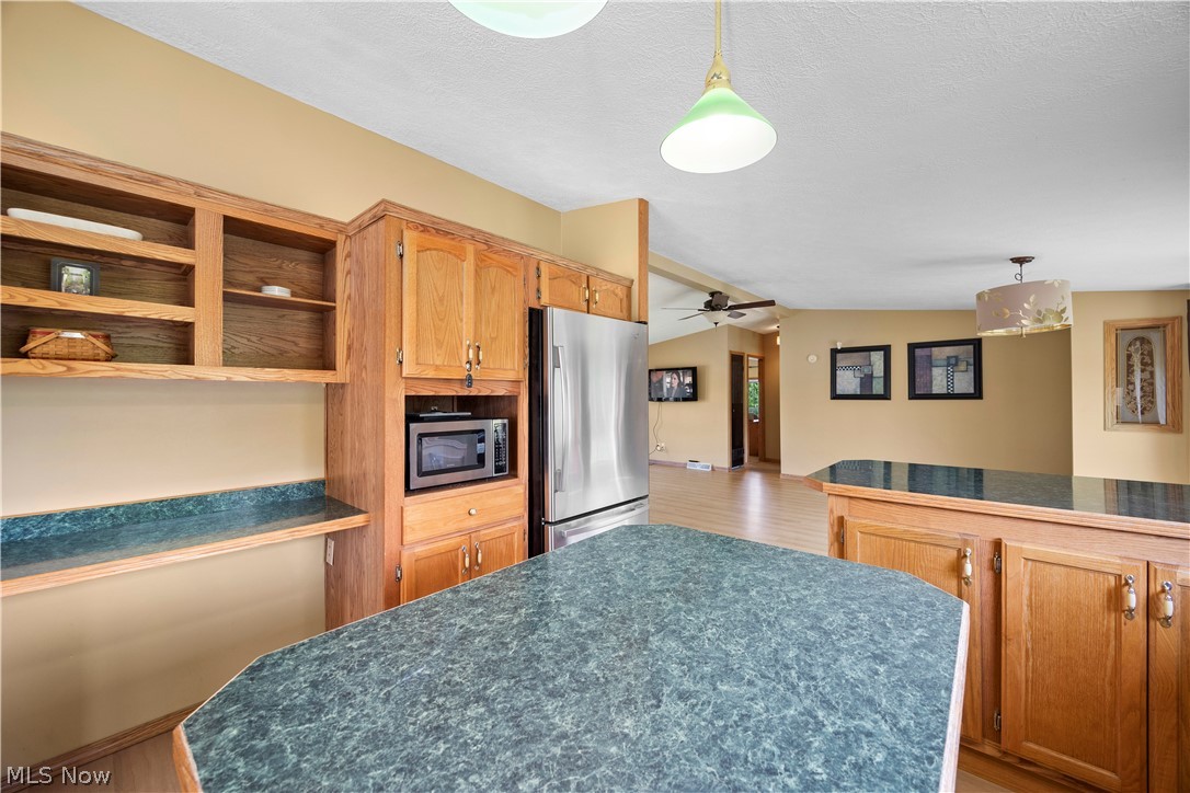 294 Twp 150 Road Sullivan, OH 44880 - Photo 13 of 39 Kitchen featuring wood cabinetry, integrated open shelving, stainless steel refrigerator, and dark speckled countertops